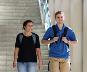 male and female student coming down stairs at heider college of business