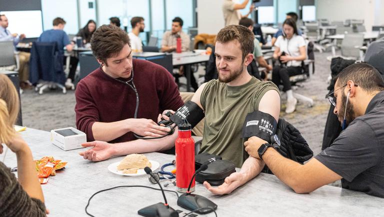 medical students taking blood pressure on each other