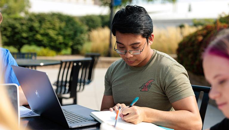 Student working outside on a table