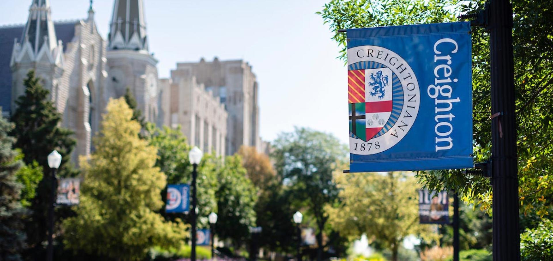Campus exterior focused on blue Creighton banner