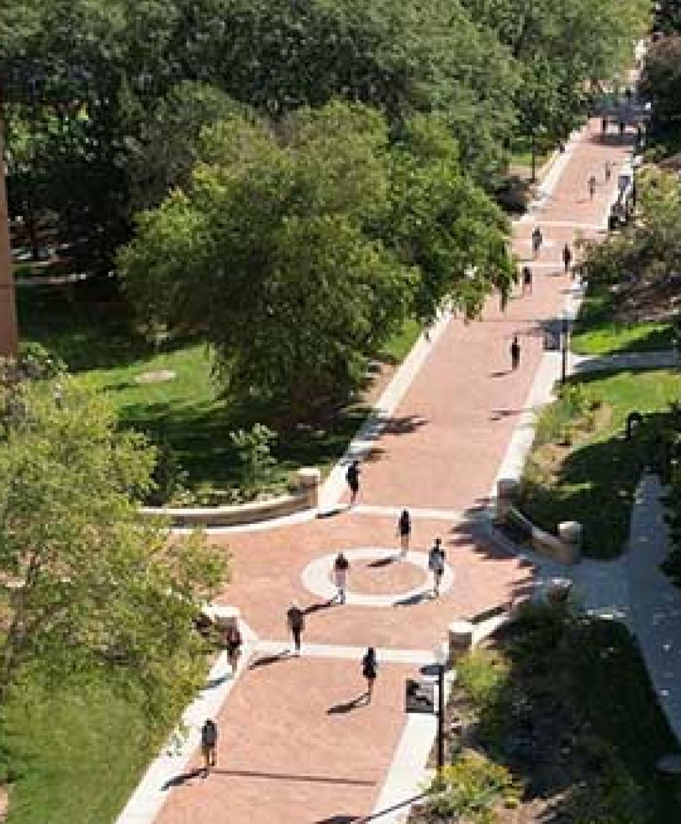 Bird's eye view on sunny day of people walking down Creighton mall past McGloin Residence Hall.