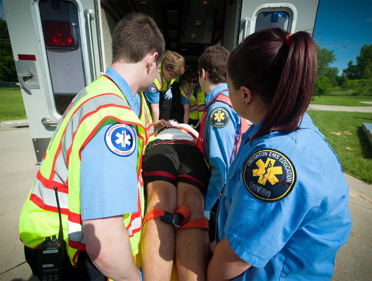 EMS providers loading a patient on a stretcher into an ambulance