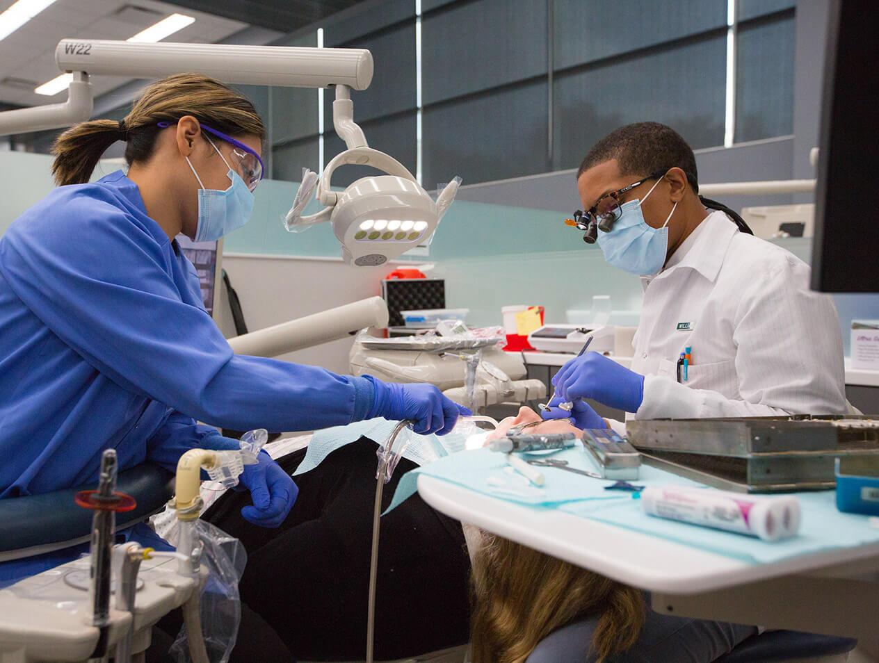 Dental students performing a dental procedure on a patient