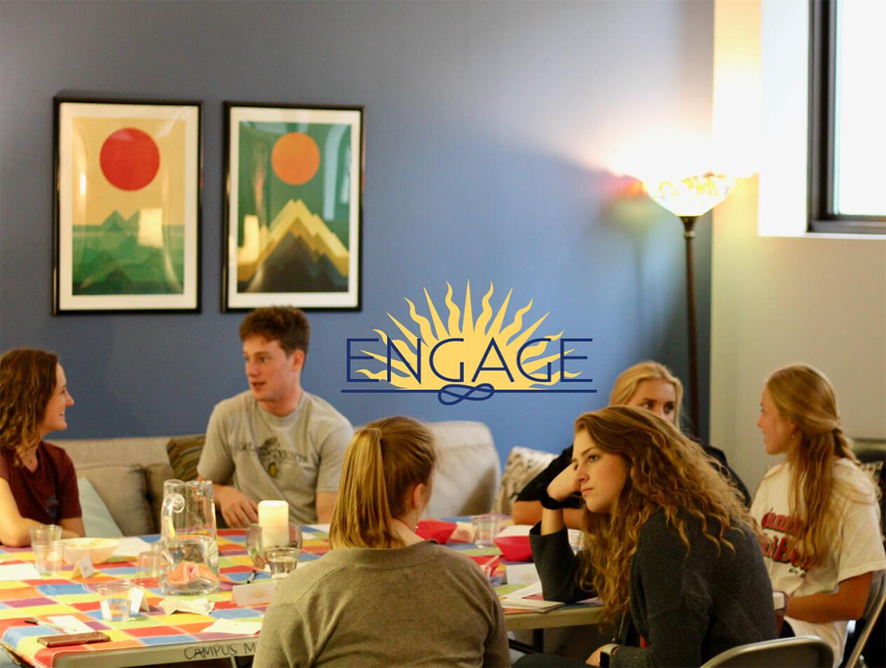 Students sitting at a table and talking during an ENGAGE event