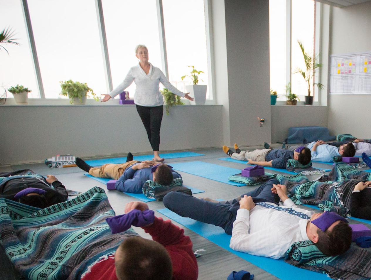 yoga participants relaxing in campus building setting.