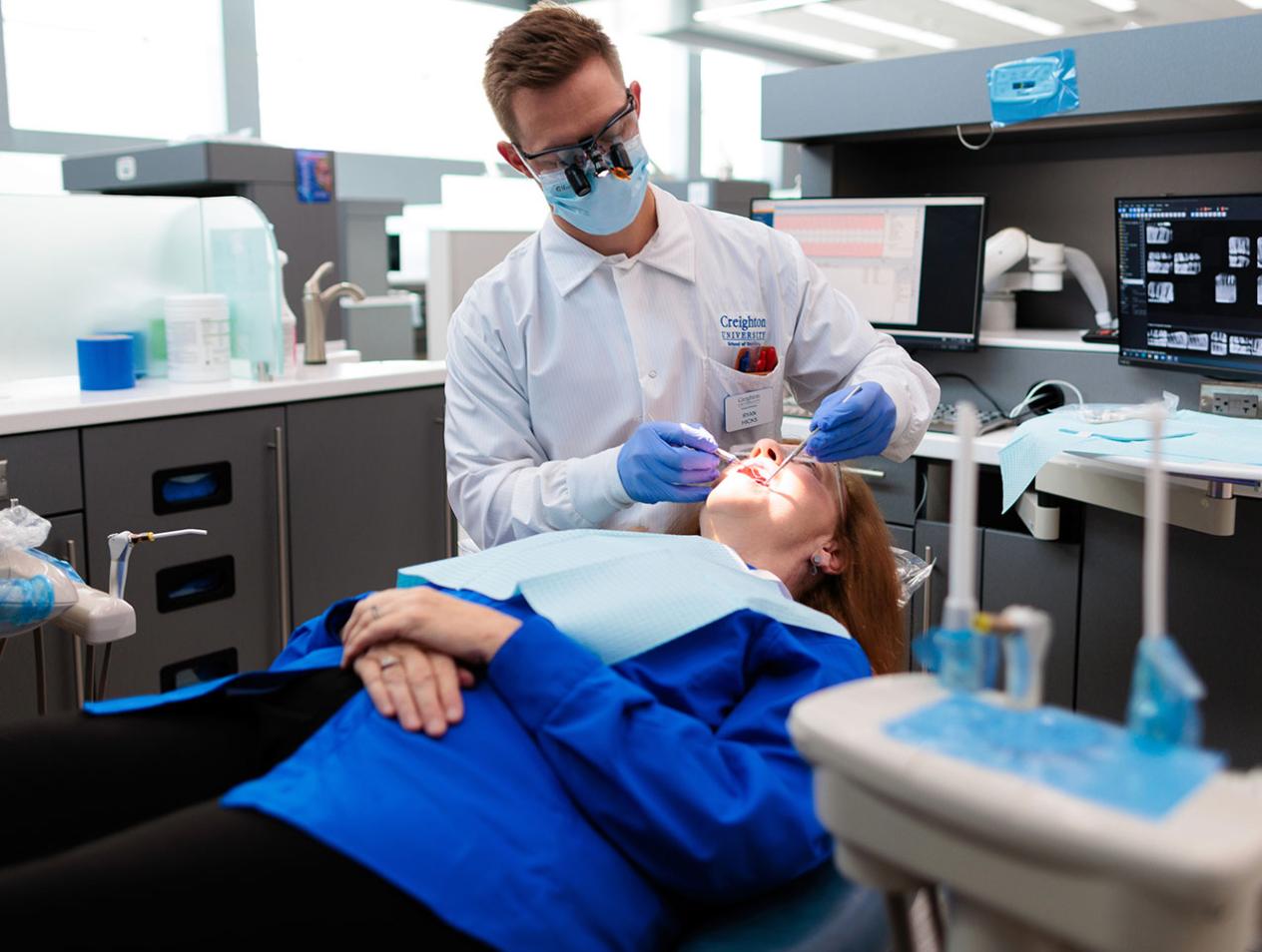 Student examining patient's teeth