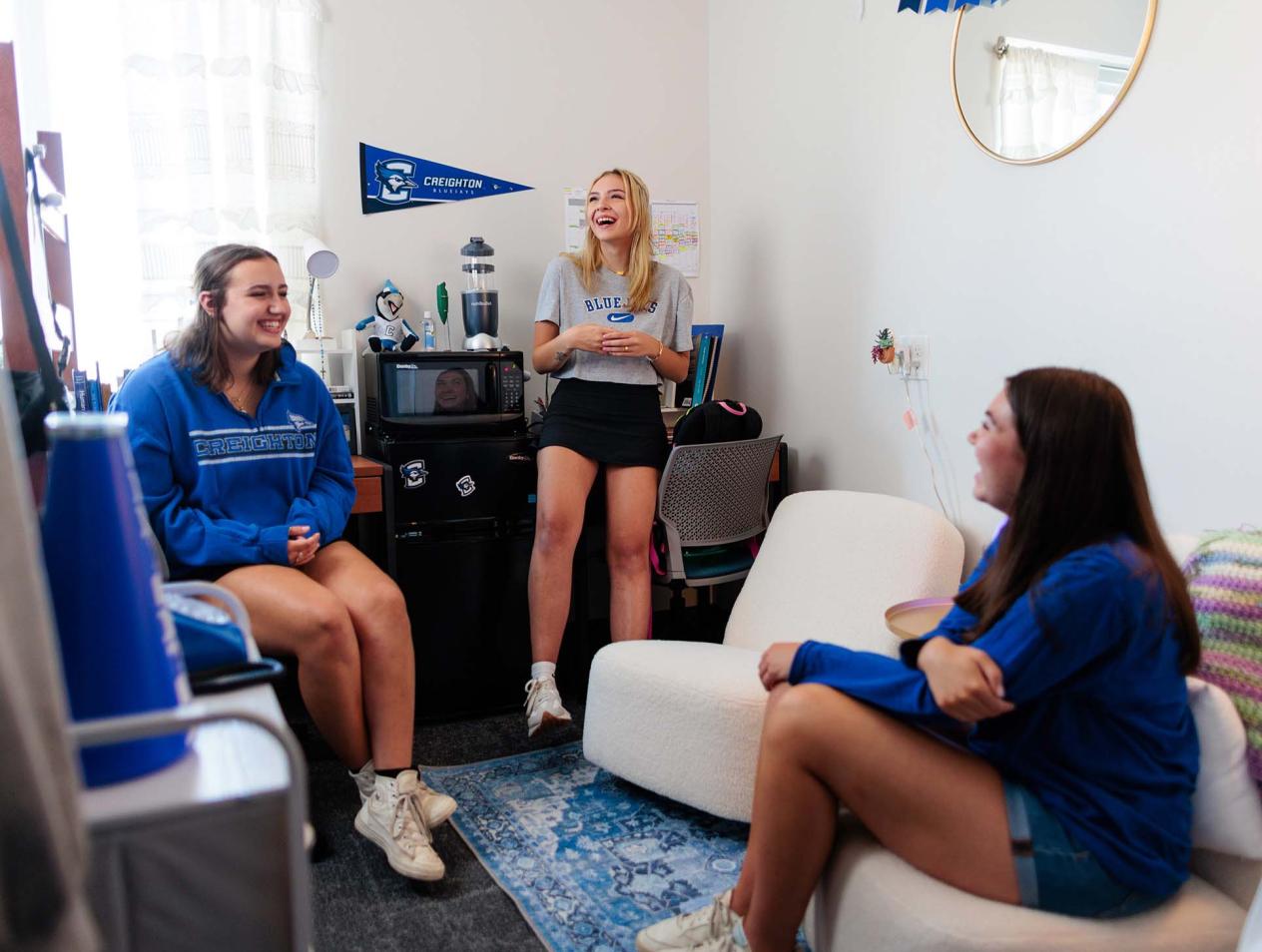 Students smiling in their residence hall room.