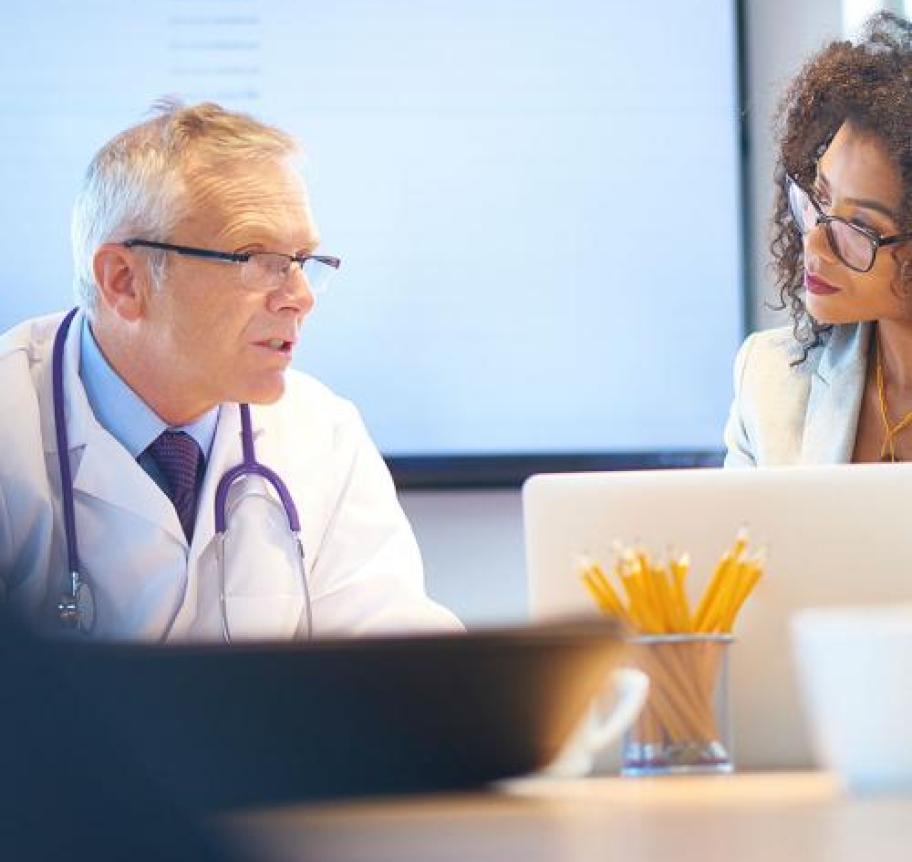 Medical professionals consulting in front of a laptop