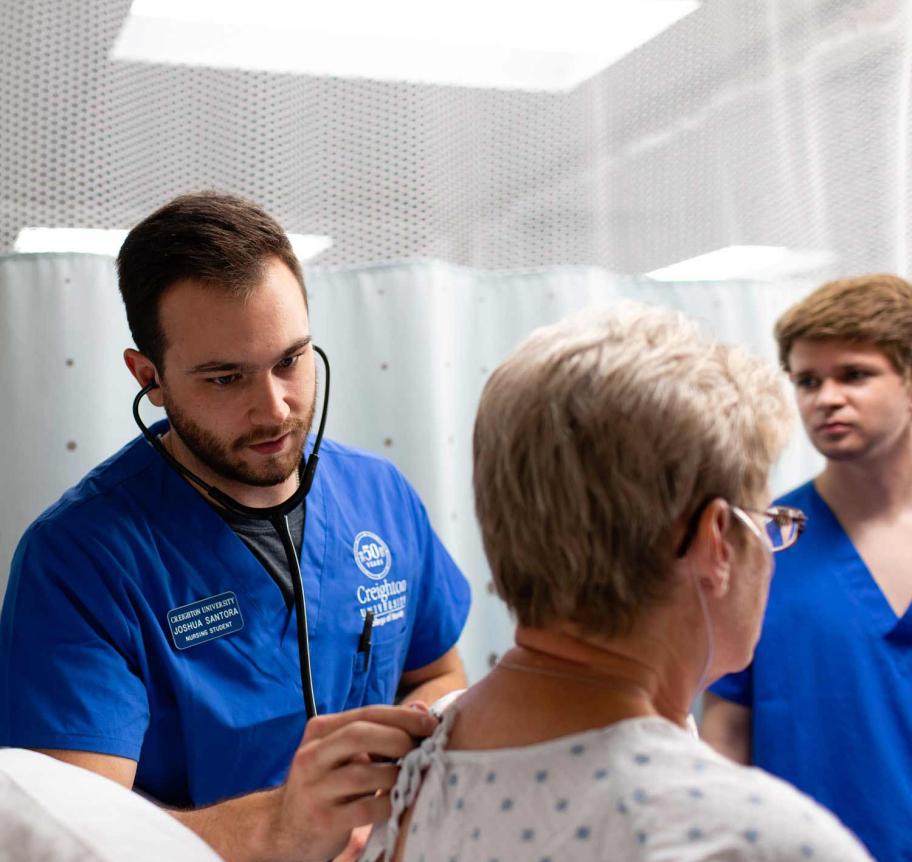 Nursing students assessing patient