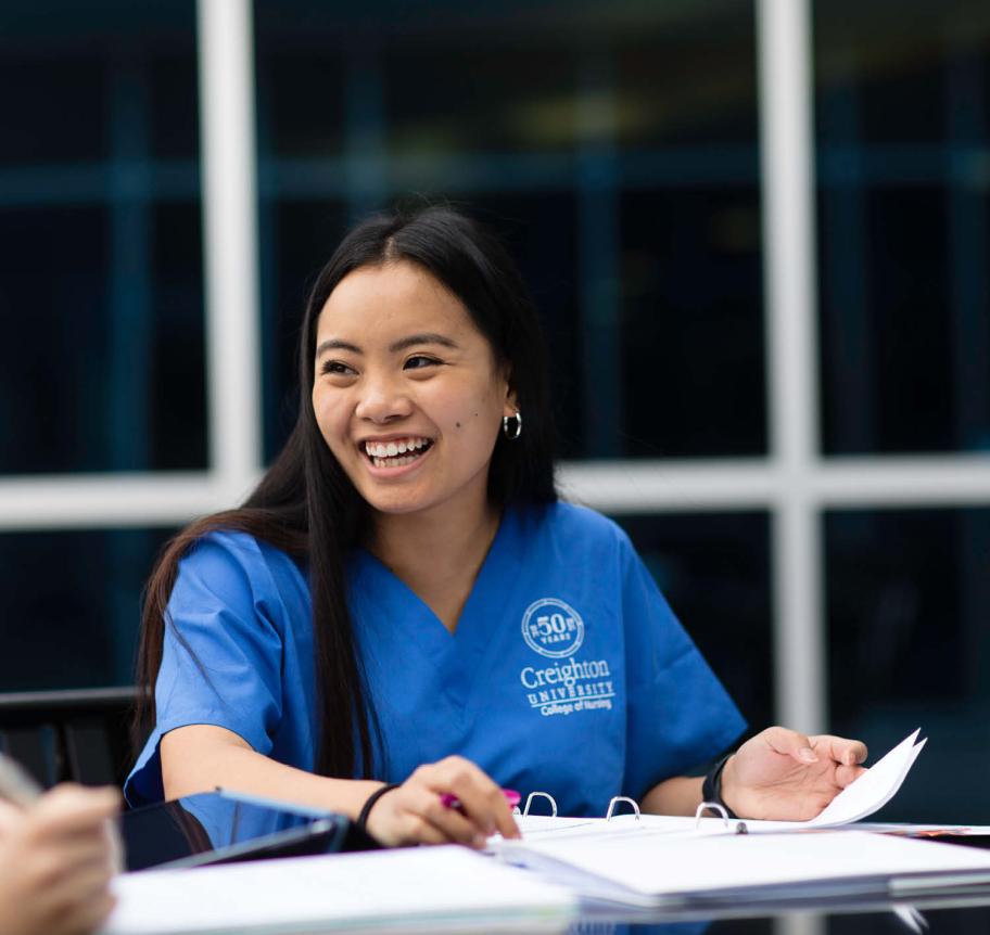 Nursing student smiling while studying at table