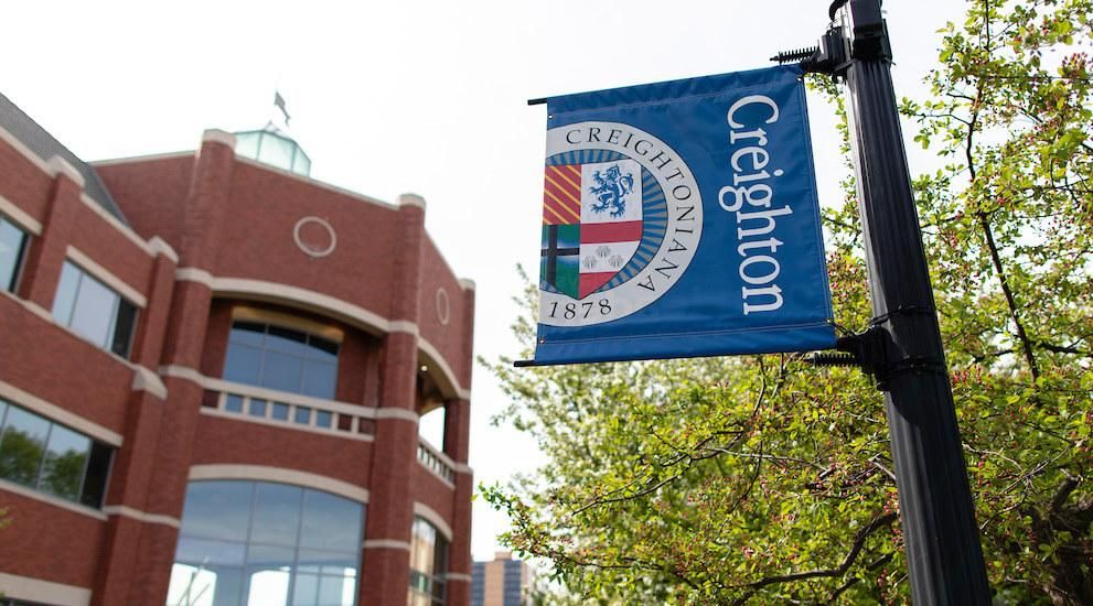 Creighton seal banner with Heider College of Business in the background
