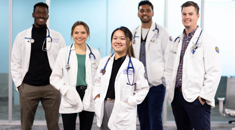 diverse medical students with white jackets and stethoscopes