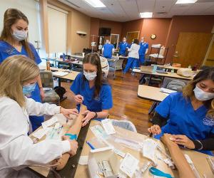 Nursing students getting hands-on experience in classroom