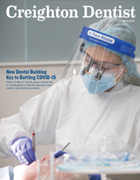 Creighton Dentist cover of magazine with dental student working in lab