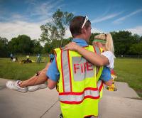 Fire dept EMS carrying a young girl during a disaster training exercise