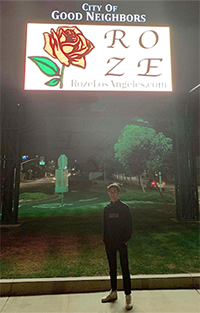 Bradley Gilkerson standing under a sign advertising Roze Los Angeles
