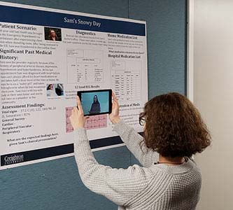 Intern demonstrating how to use augmented reality on posters