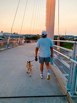 Dominic Jasso walking his dog on the Bob Kerrey Pedestrian Bridge.