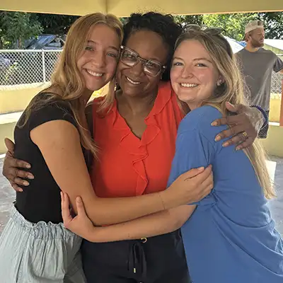 Students embrace during summer trip to Dominican Republic.