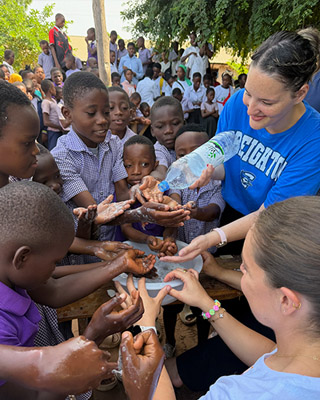 Assisting with children handwashing in Togo.