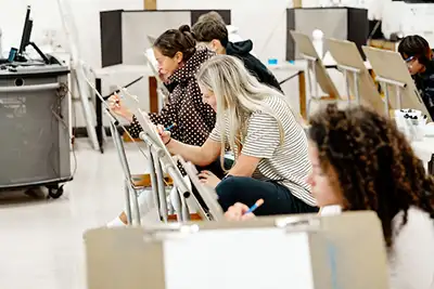 Students drawing at easels