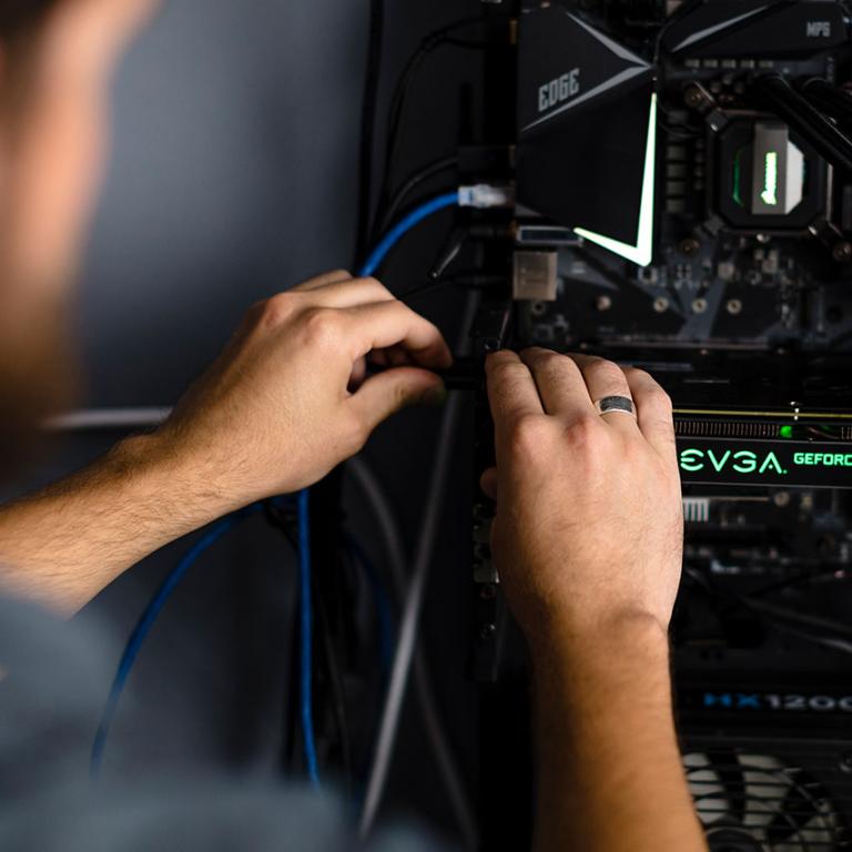A person adjusting cables on a server