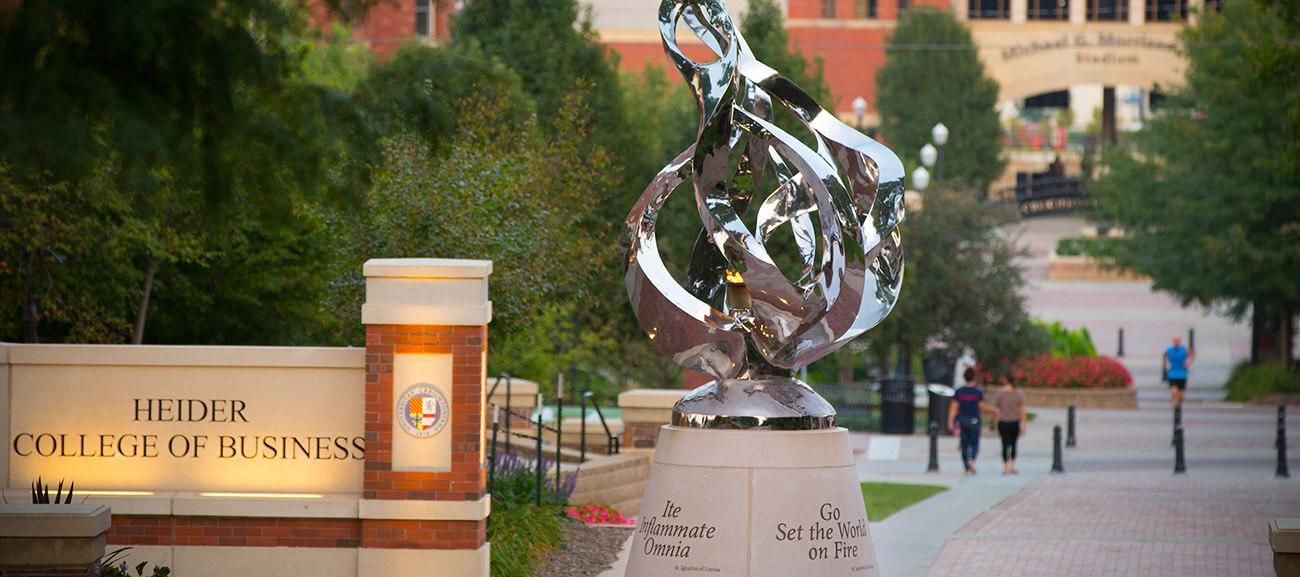 The flame sculpture with the Heider College of Business sign in the background