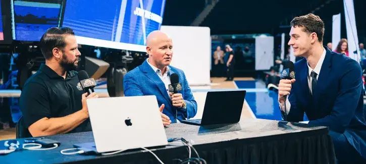 Kalkbrenner being interviewed on the set at a basketball game.