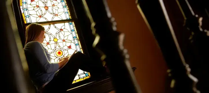 Student studying in church setting.