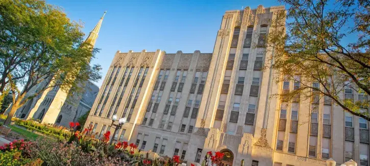 Creighton Hall with blooming flowers featured in foreground.