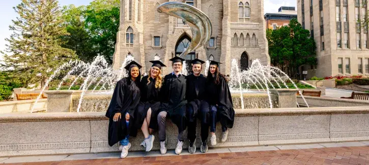 Graduating seniors posing in front of the fountain on Creighton's campus.