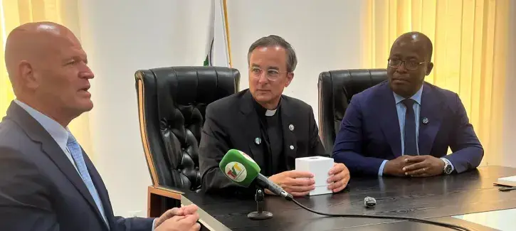 Father Hendrickson at signing agreement with colleagues.