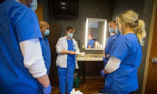Nursing students gathered around a faculty member
