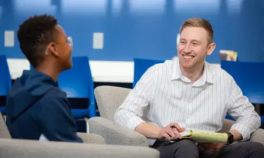 Consulting with student in office setting.