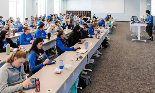 Wide shot of classroom filled with students.