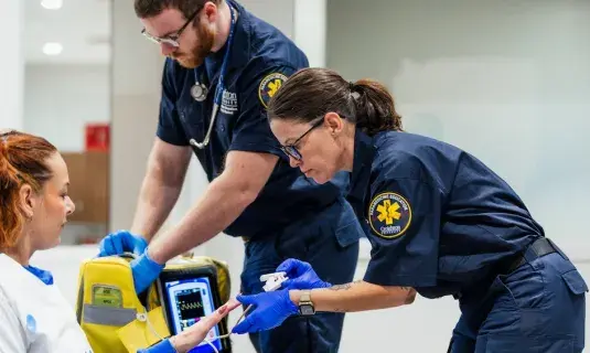 Two paramedics caring for a patient.