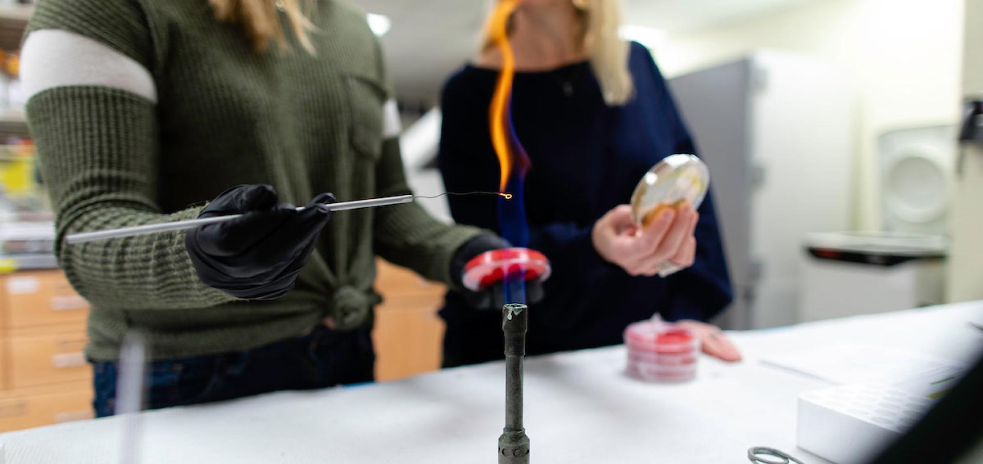 Student and professor working over bunsen burner flame