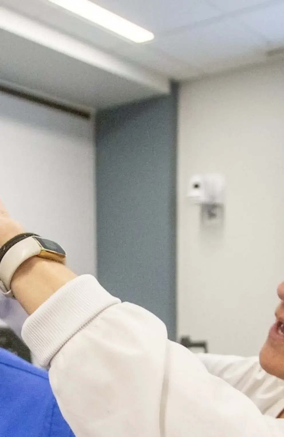 Professor adjusting VR goggles for student.