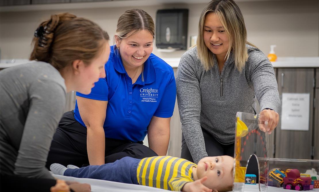 Three therapists working with infant