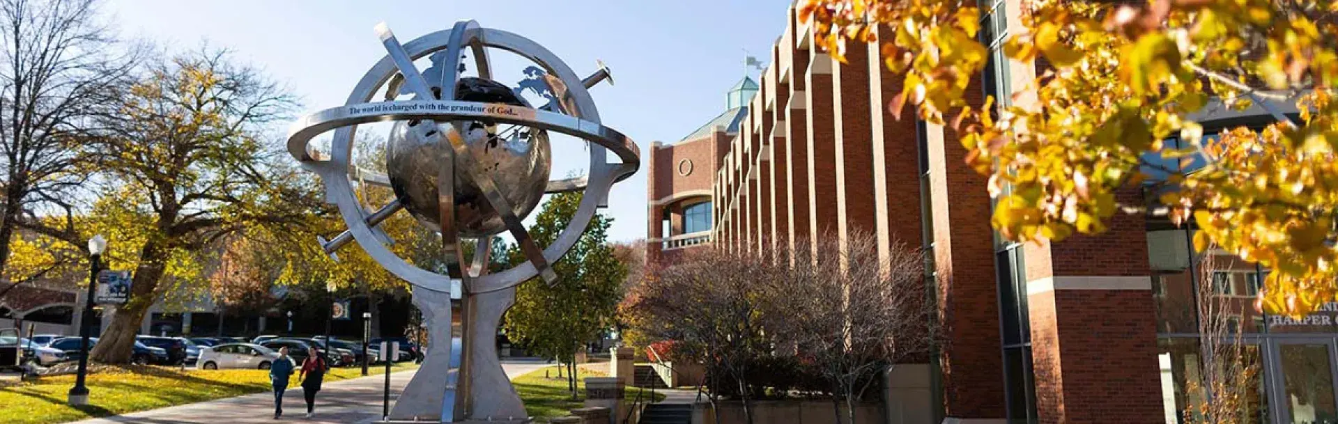 People walking on sunny day outside Heider Business College.