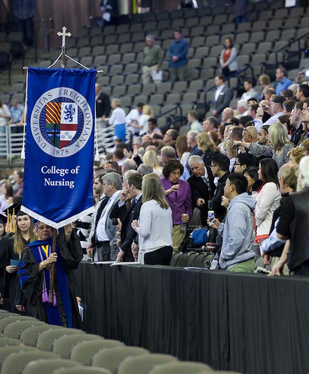 Nursing commencement ceremony with College of Nursing banner
