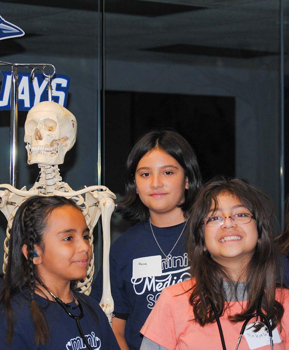 group of diverse girls and a skeleton