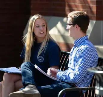 Students sitting outside on bench