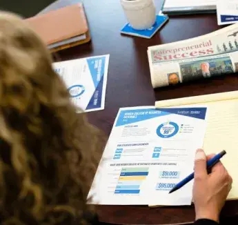 A woman looking over a financial data printout
