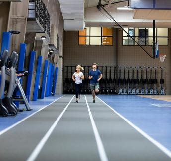 Two students running on the track at the Kiewit Fitness Center