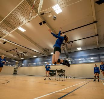 Student spiking a ball during a volleyball game