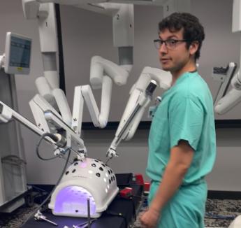Student with robotic surgery equipment