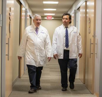 Two doctors walking down hallway.