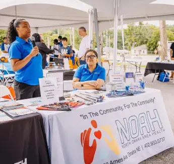 The NOAH (North Omaha Area Health) booth offers free health screenings including blood pressure, diabetes, and depression checks at a community event.