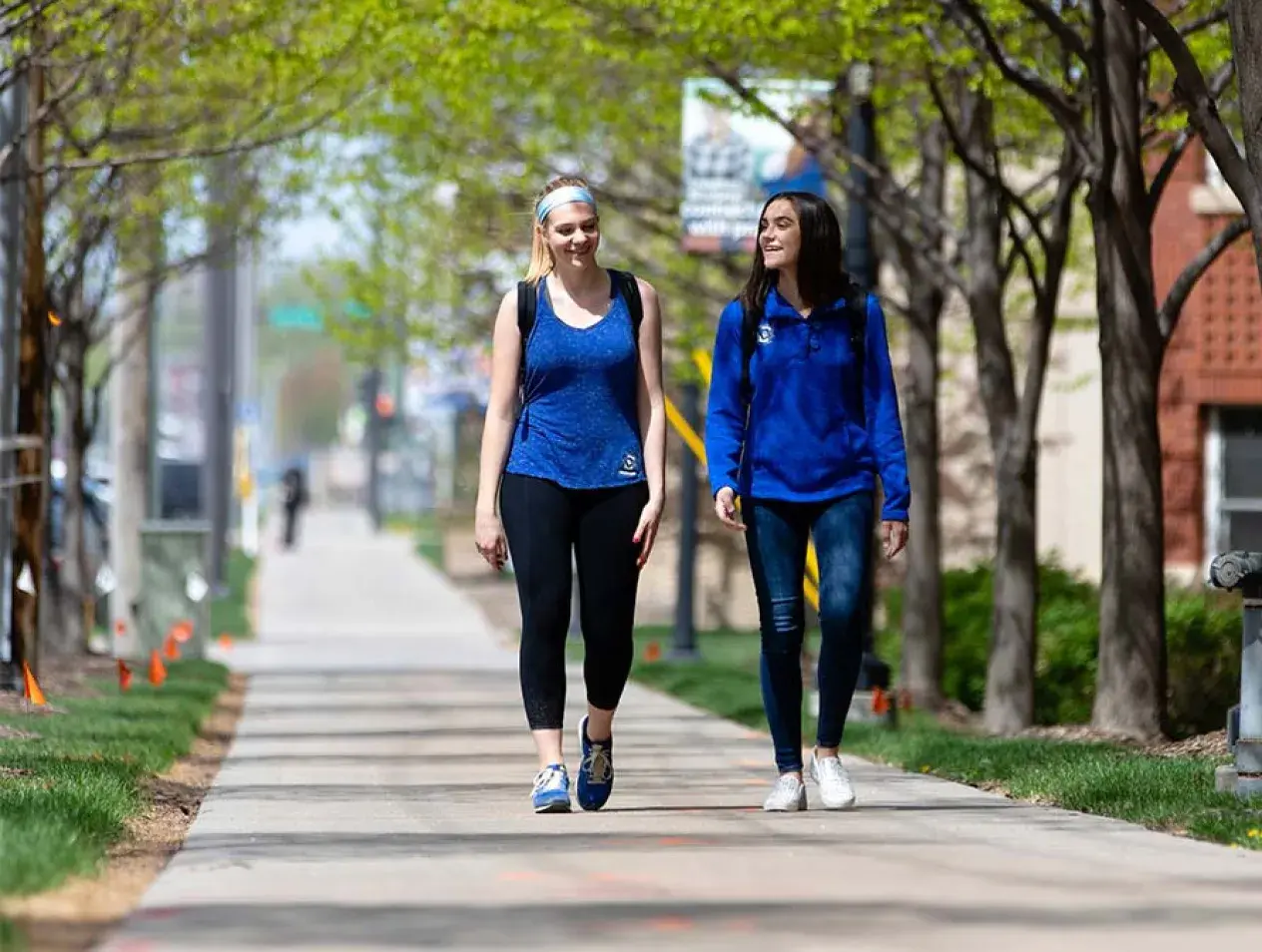 Two students walking on campus in summer